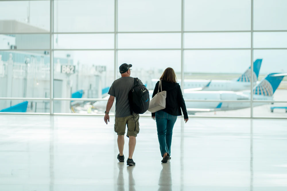 Two travelers walking through a bright airport terminal