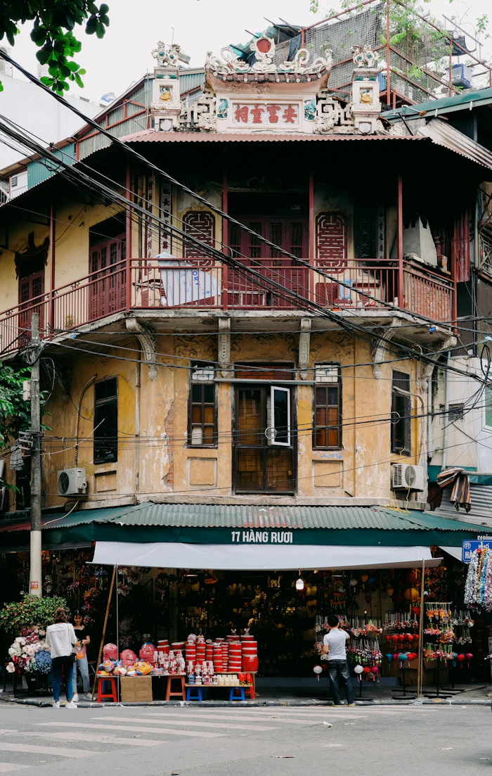 A yellow colonial-era shophouse with balconies in Hanoi