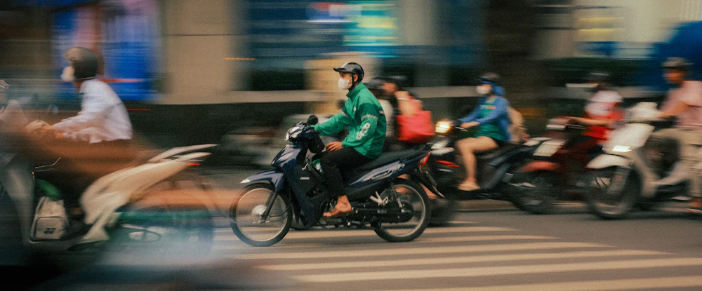 Motorbikes moving through traffic on a Vietnamese street