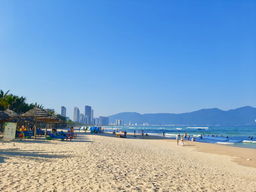 People on the sand at My Khe Beach with Da Nang's hotels behind