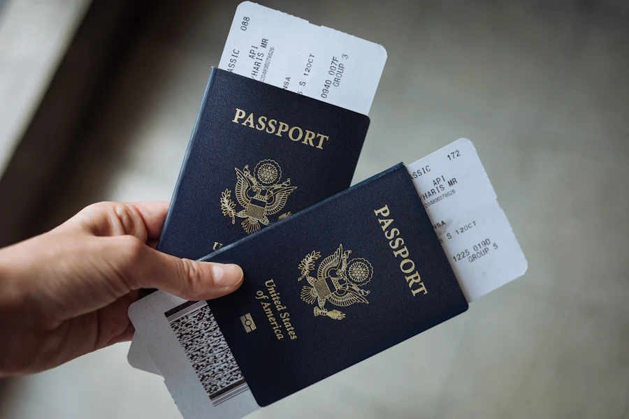 Hands holding two passports with boarding passes tucked inside